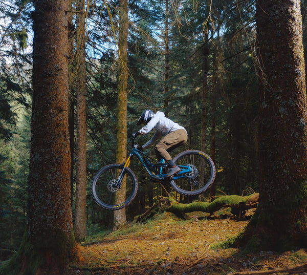 Maður brunar niður brekku í skóginum á bláu Orbea Rallon fulldempuðu enduro hjóli