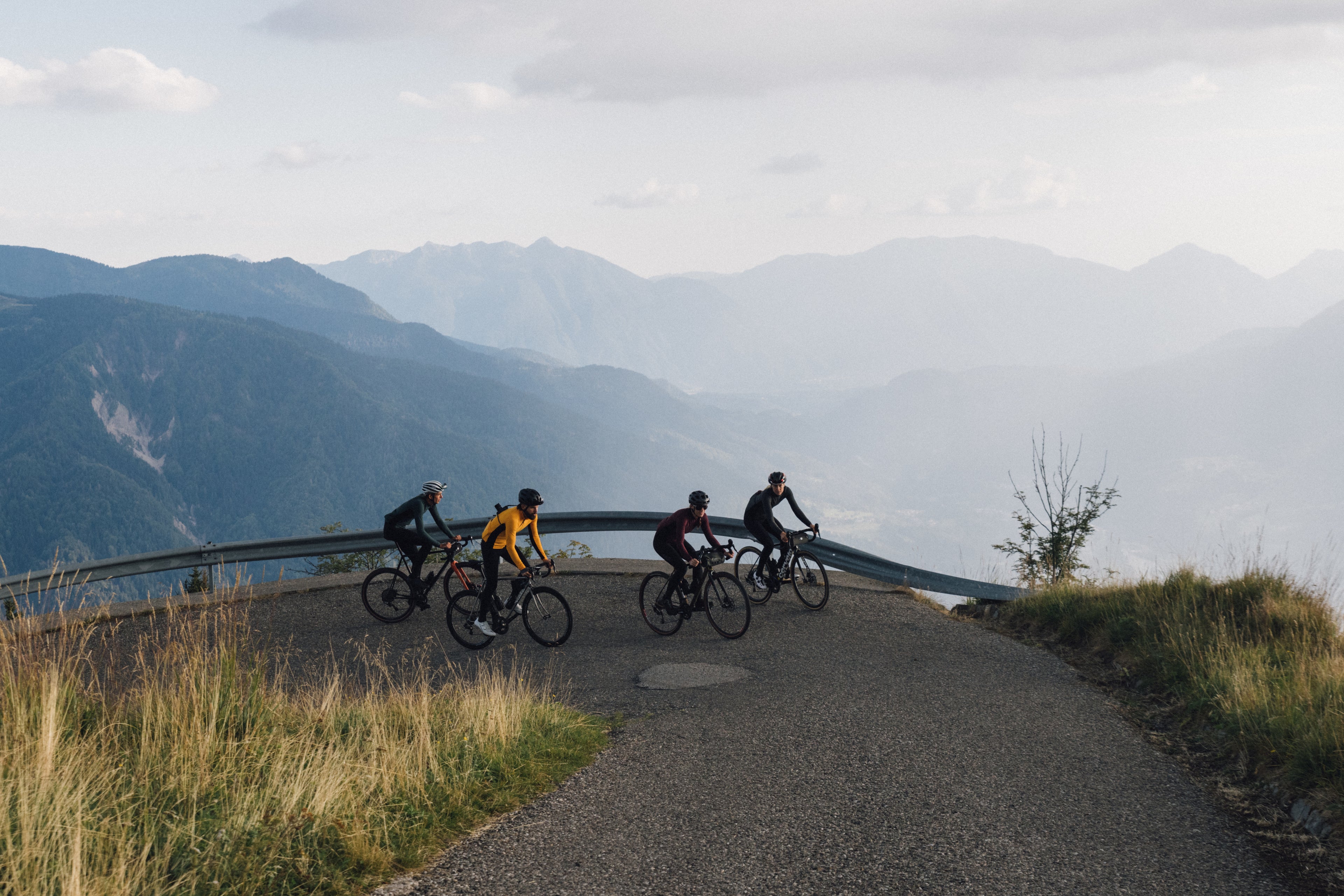 Hópur af hjólreiðamönnum í PEdALED hjólafatnaði að hjóla upp fjall